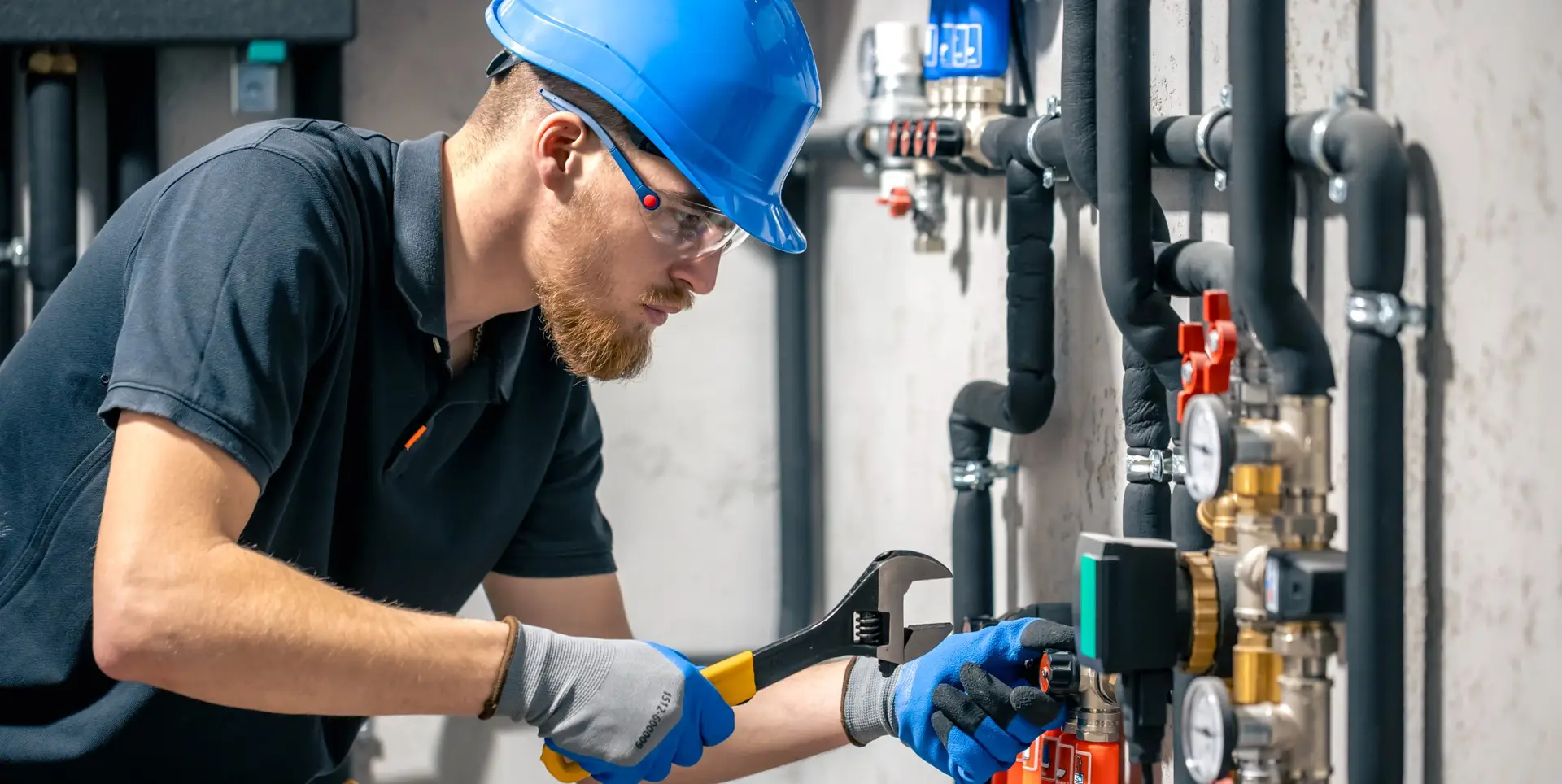 man installs heating system house checks pipes with wrench