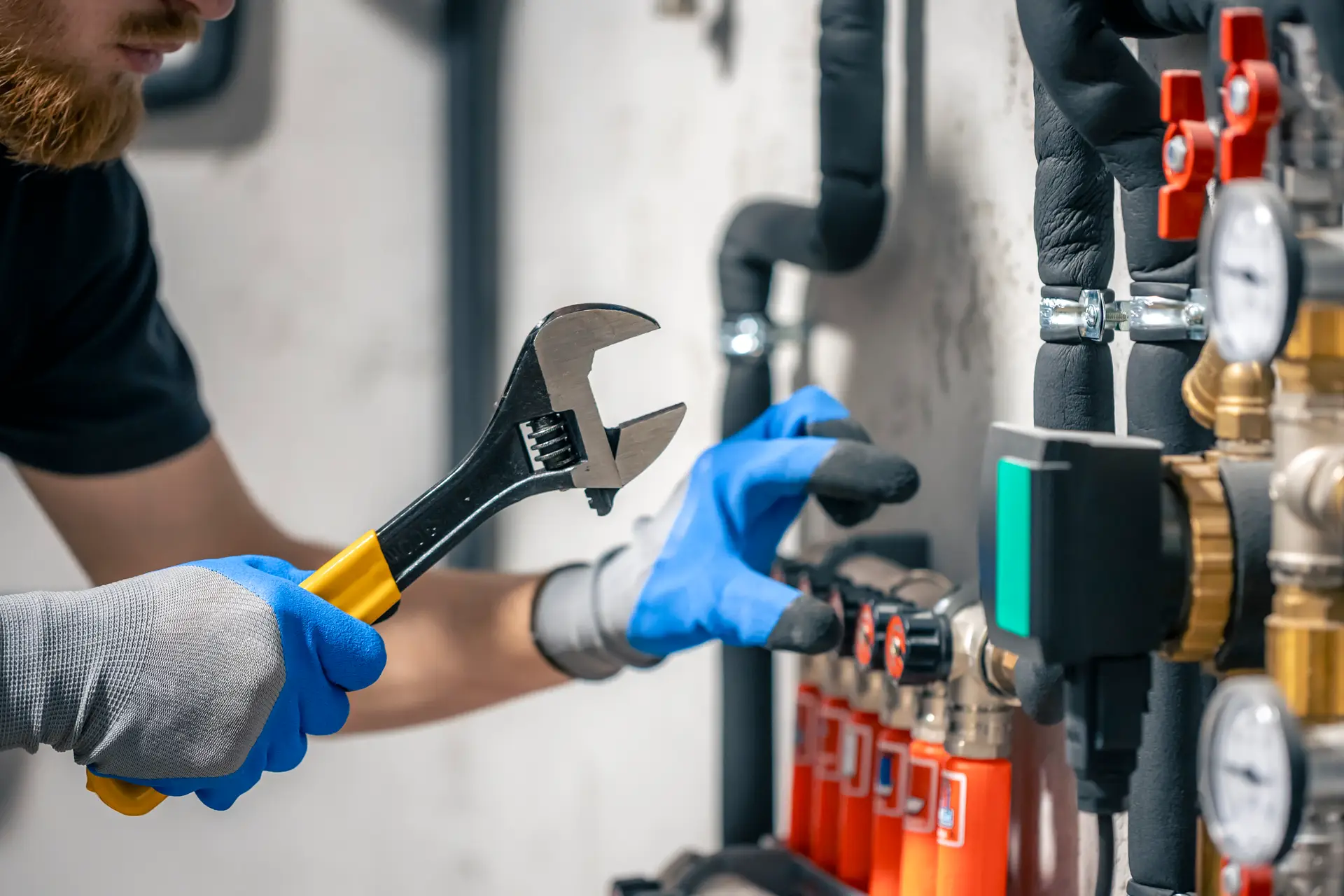 man installs heating system house checks pipes with wrench uk