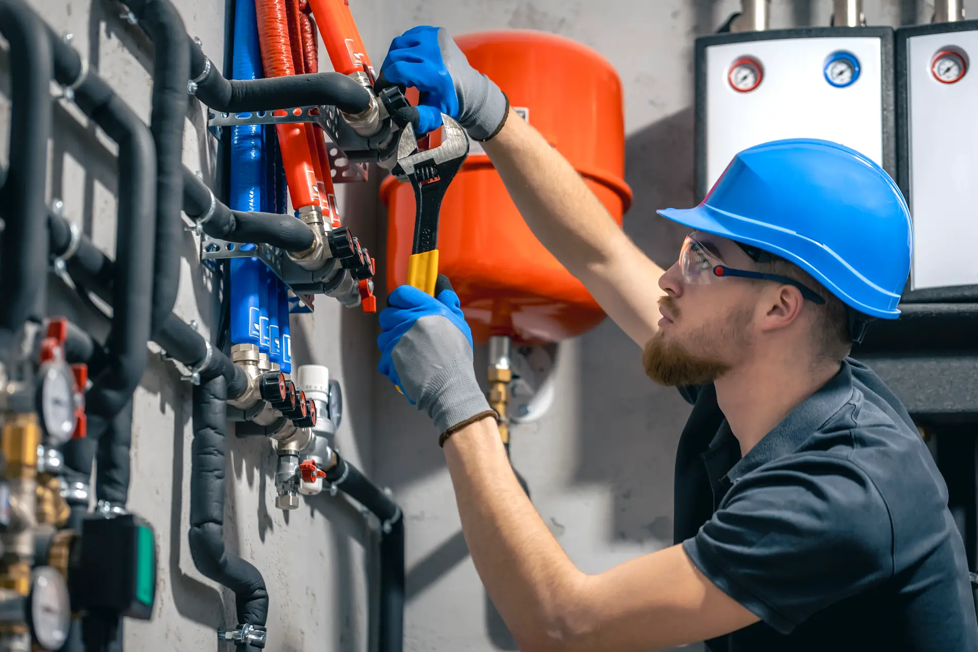 man installs heating system house checks pipes with wrench